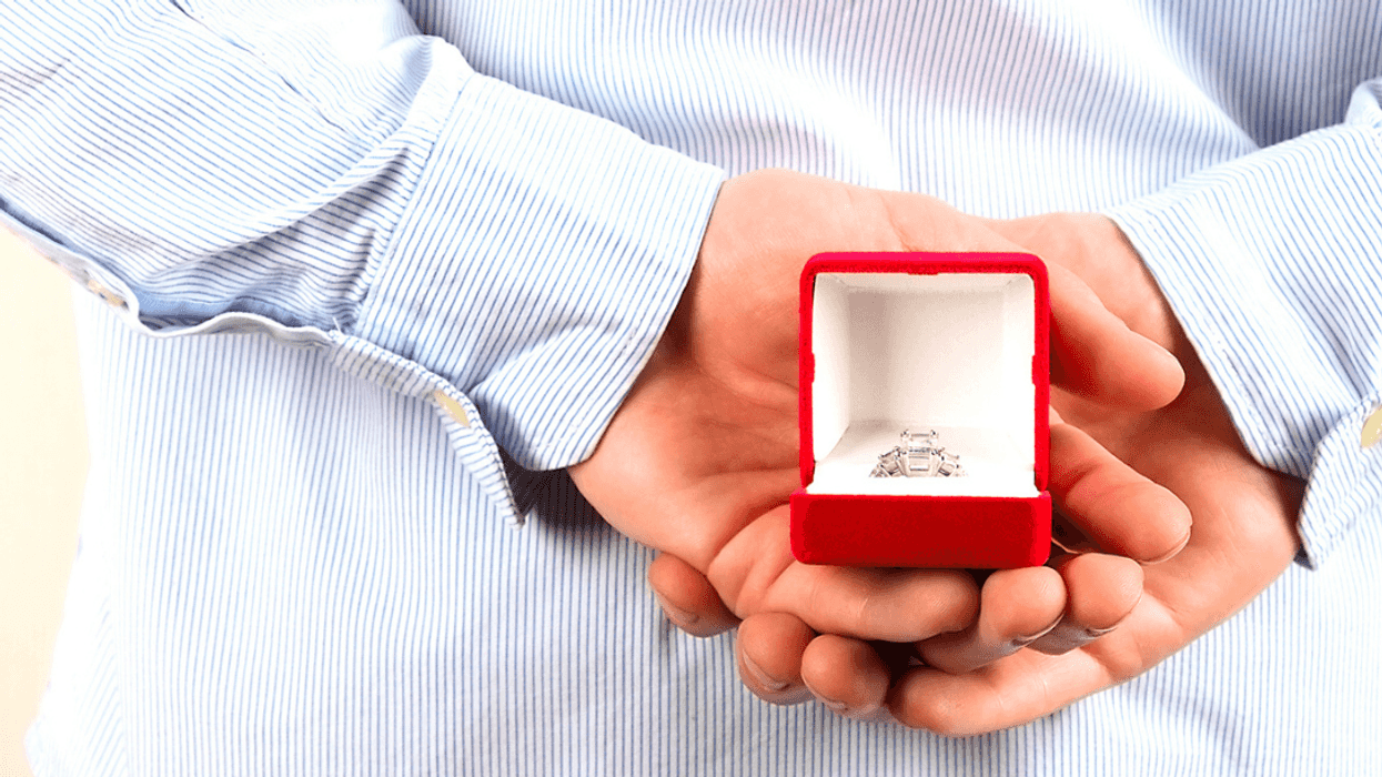 Man hiding engagement ring behind his back