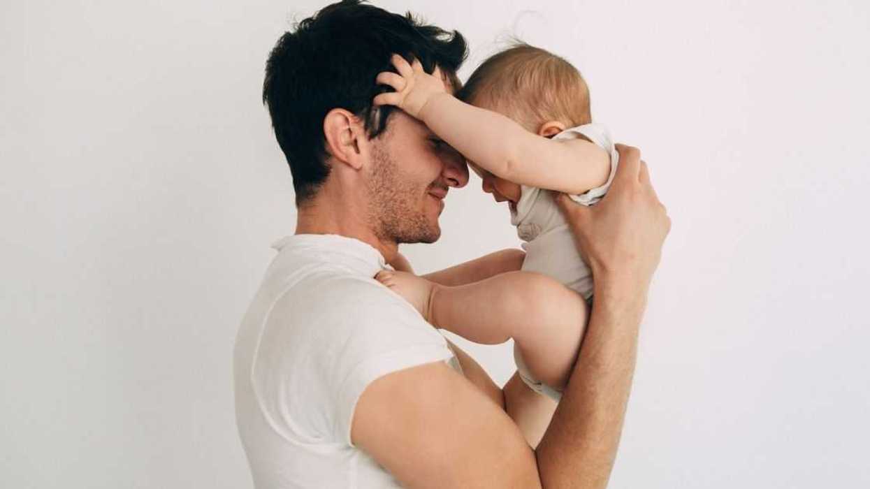 Man holding a baby face to face and smiling