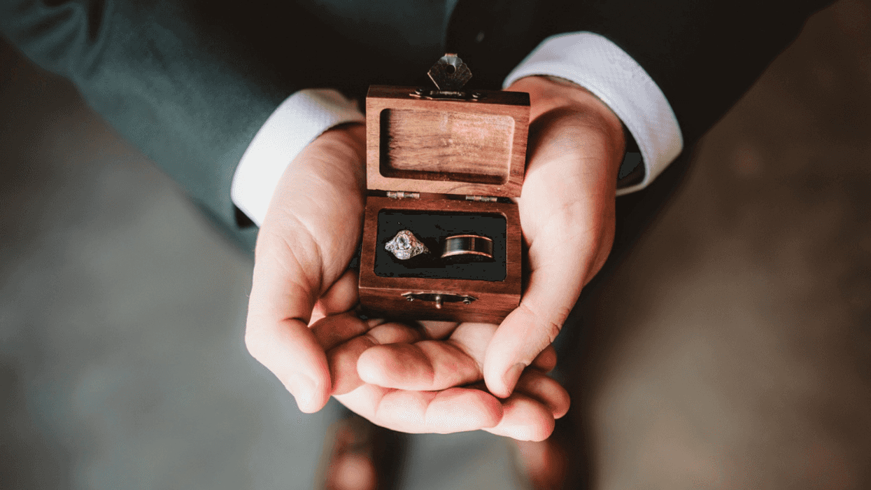 man holding box holding two wedding rings