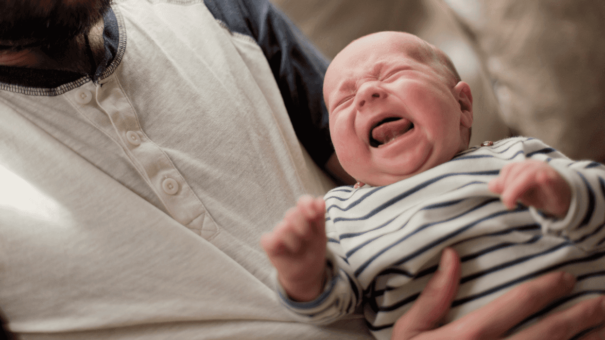man holding crying infant