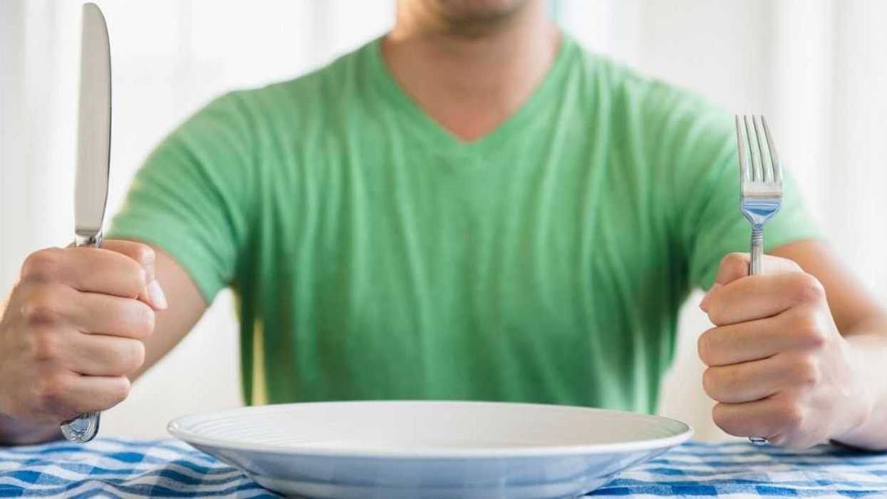 Man holding fork and knife at table