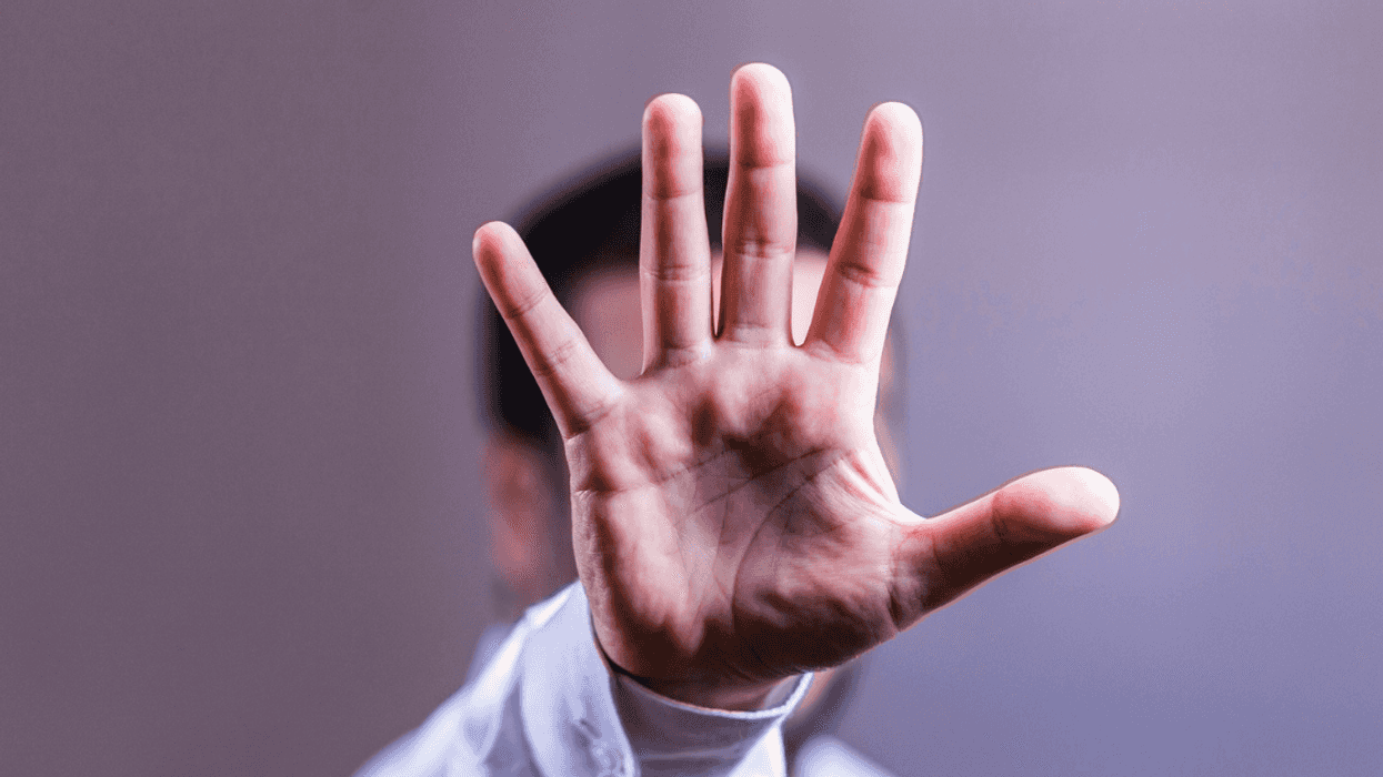 man holding his hand up tpo indicate "stop"