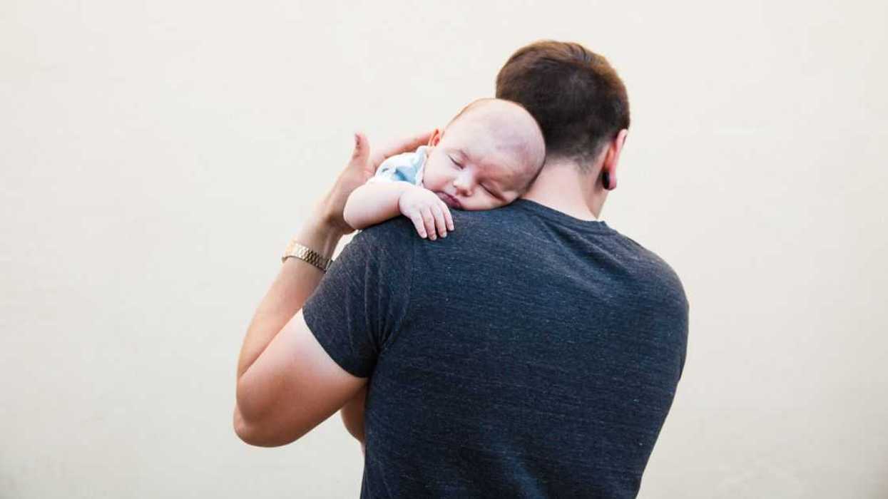 Man holding infant over the shoulder