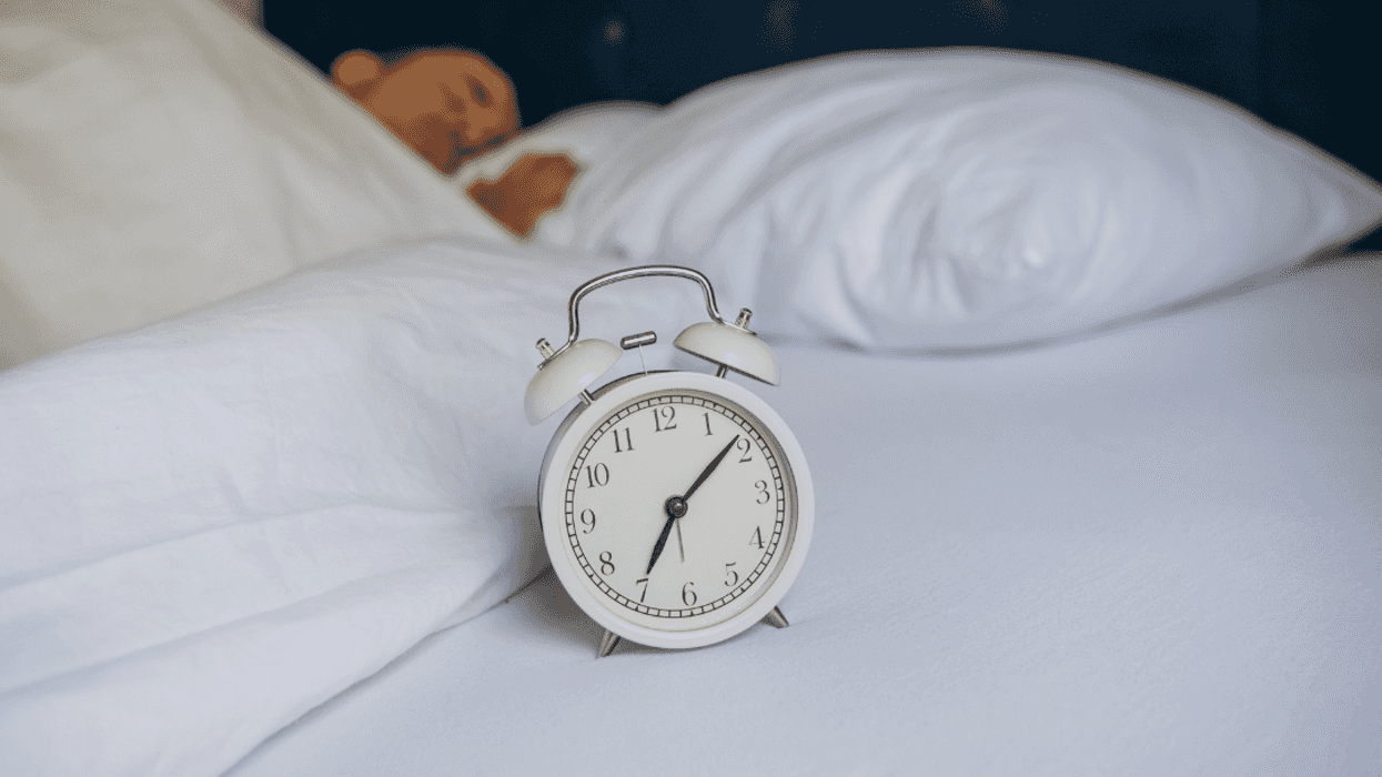 man in bed with alarm clock