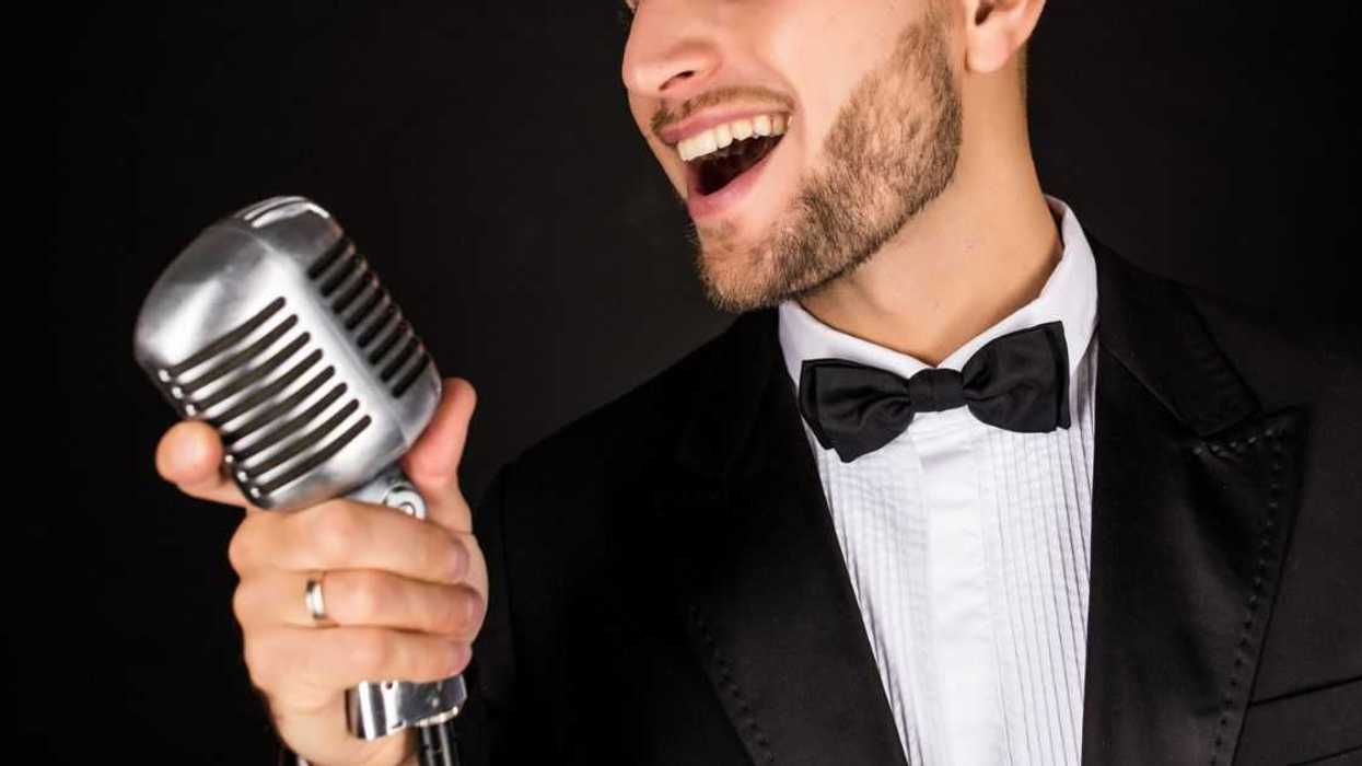 Man in tux singing into mic