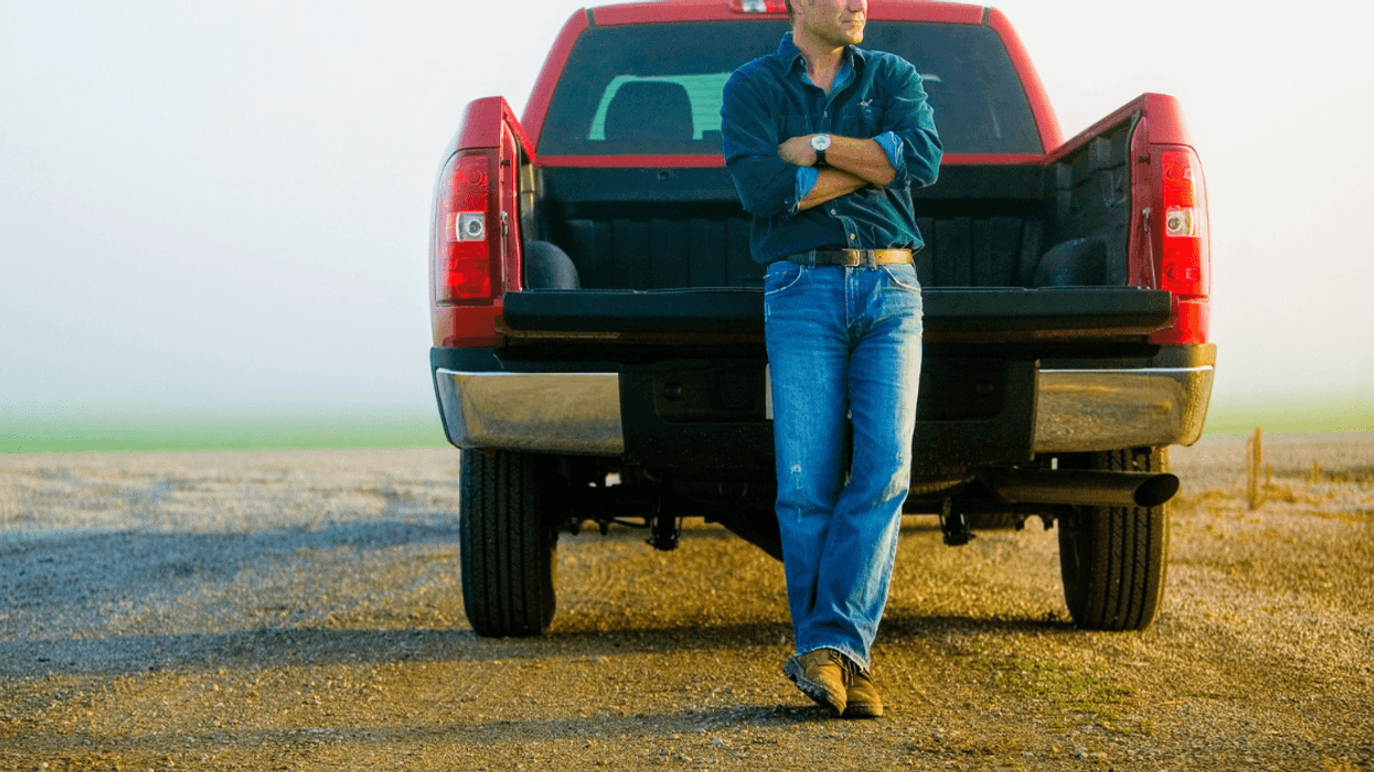 man leans against tailgate of truck