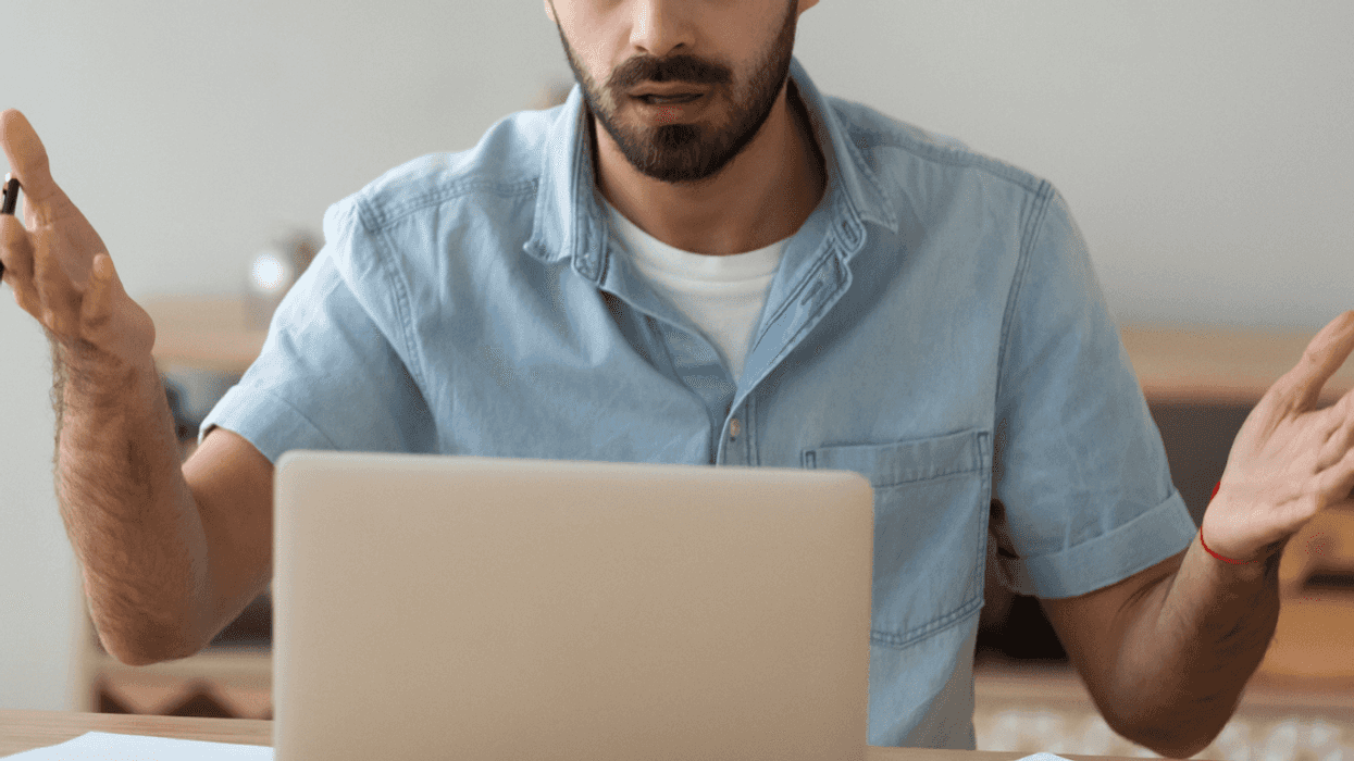 man looking at laptop with shocked expression