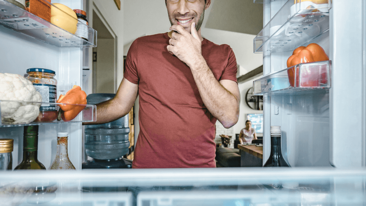 man looking in refrigerator