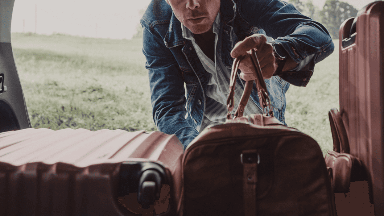 Man putting luggage into the back of his car