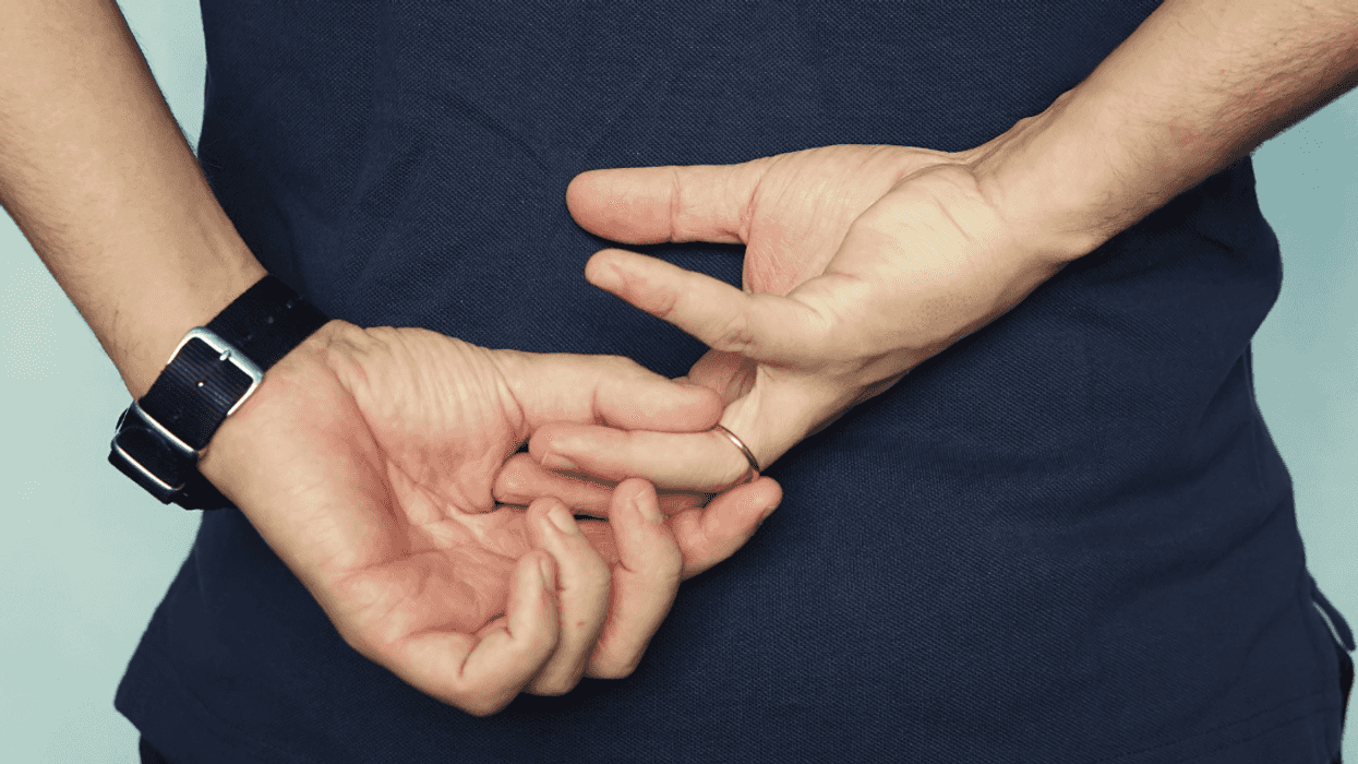 man removing wedding ring behind his back