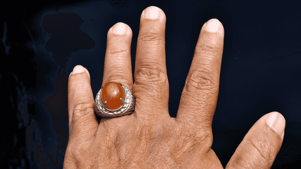 man's hand wearing large ring