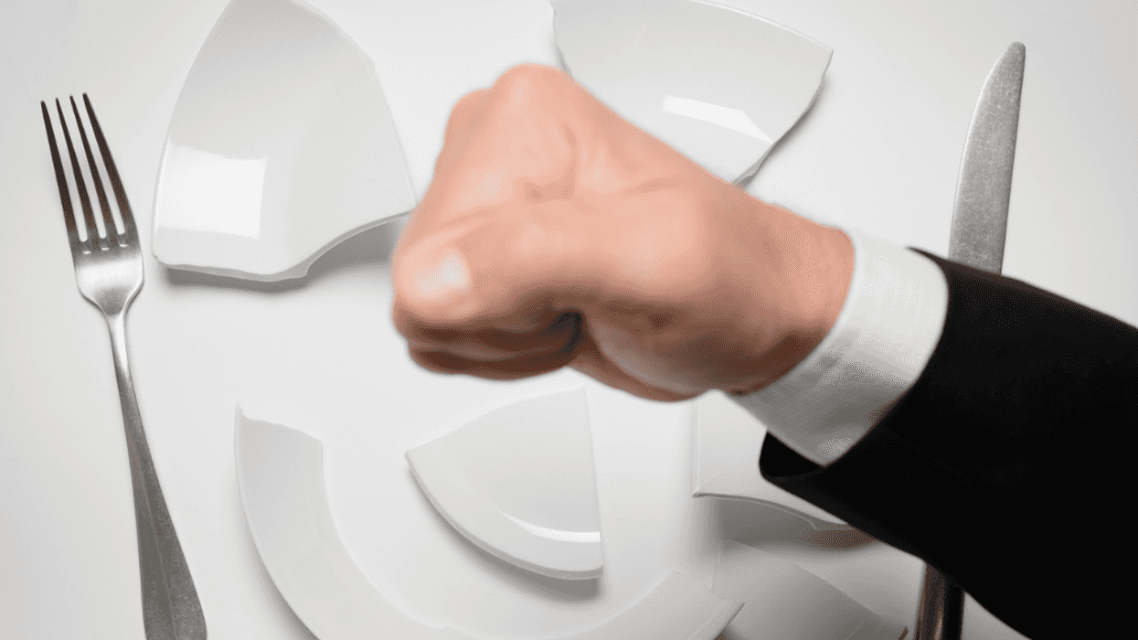 man smashing dinner plate with fist