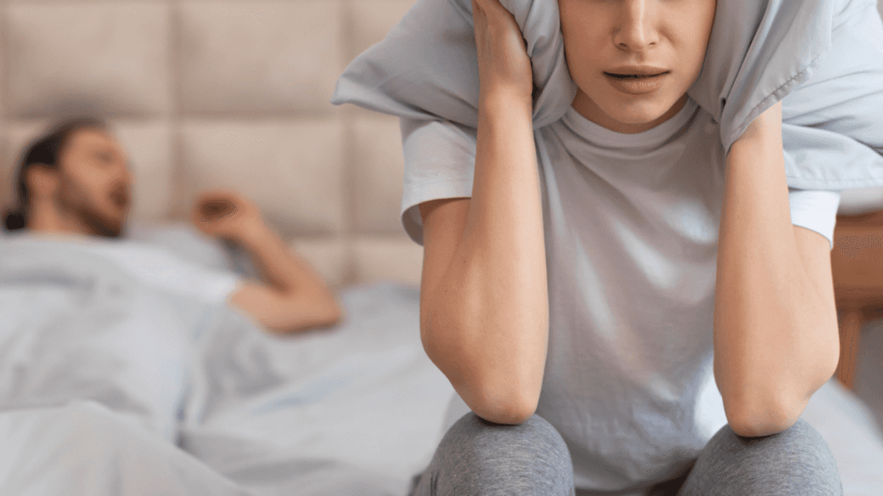 Man snoring and woman covering her ears