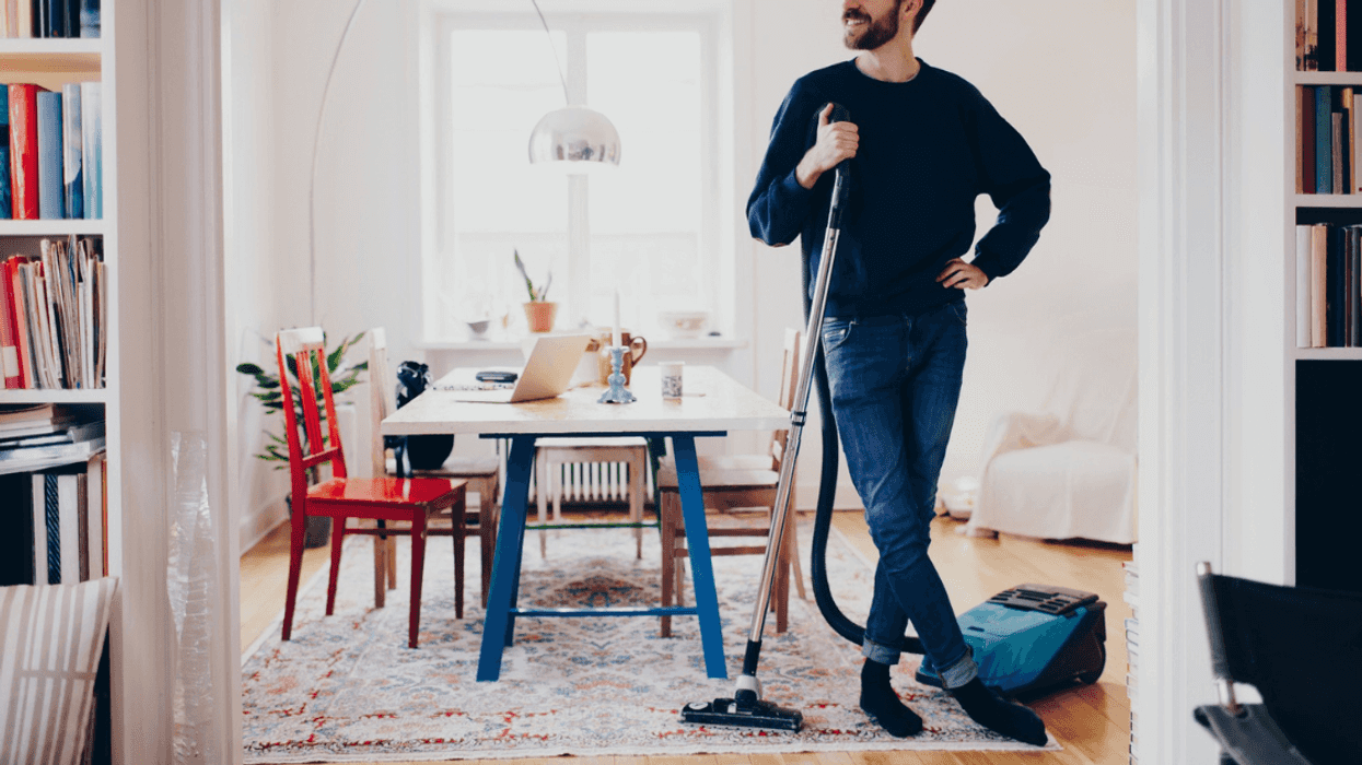 man standing with vacuum cleaner