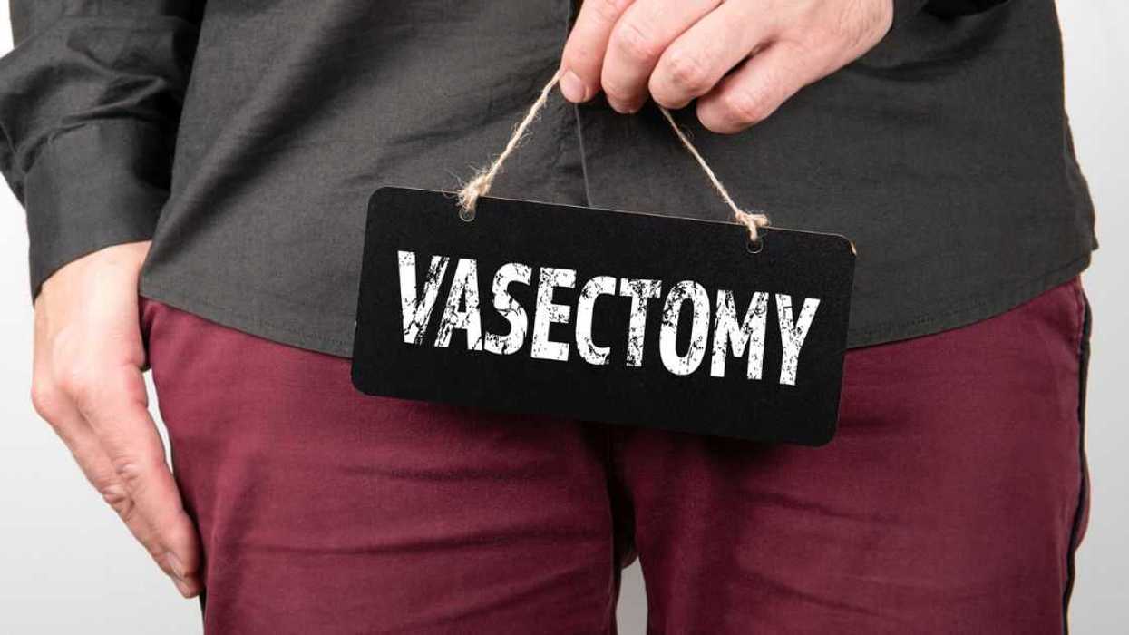 Man with small chalkboard that says 'vasectomy' dangling over his crotch
