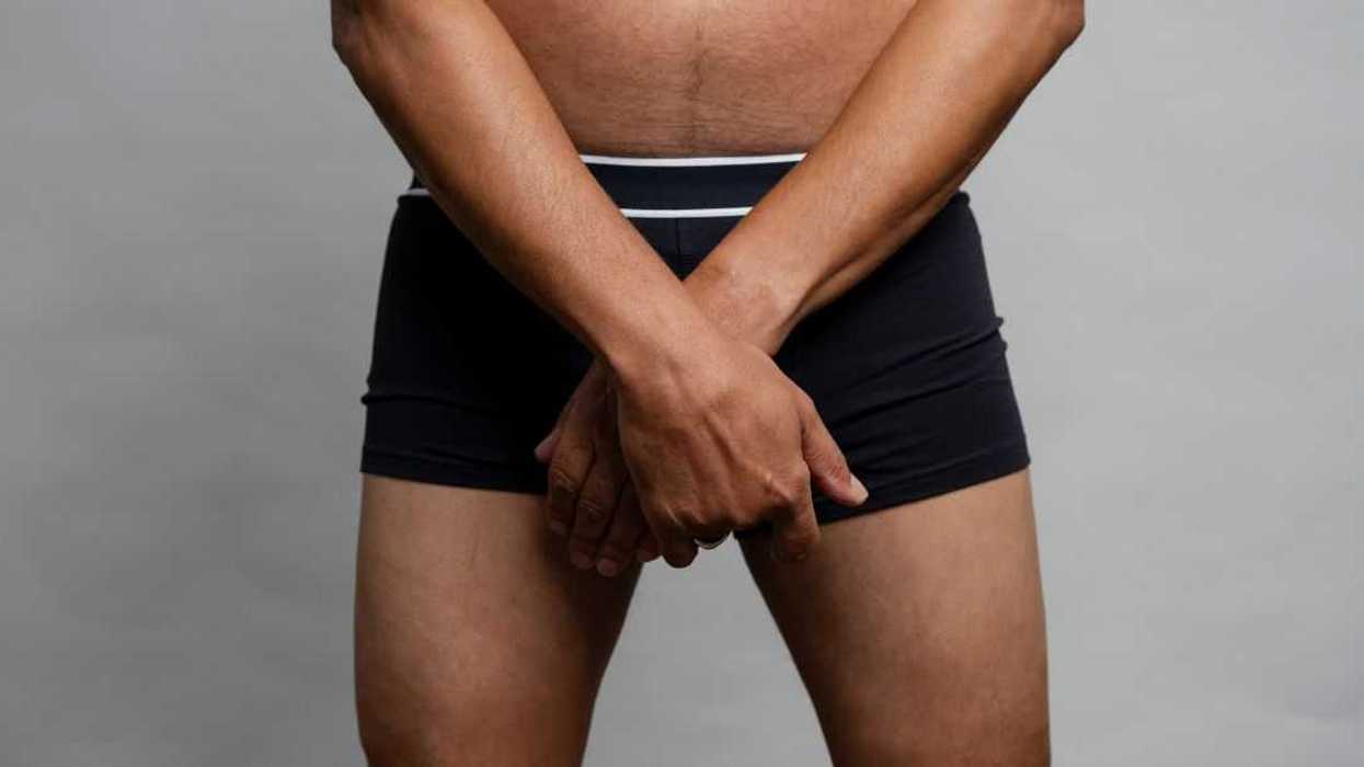 Mid section view of man wearing boxer shorts against a gray background.