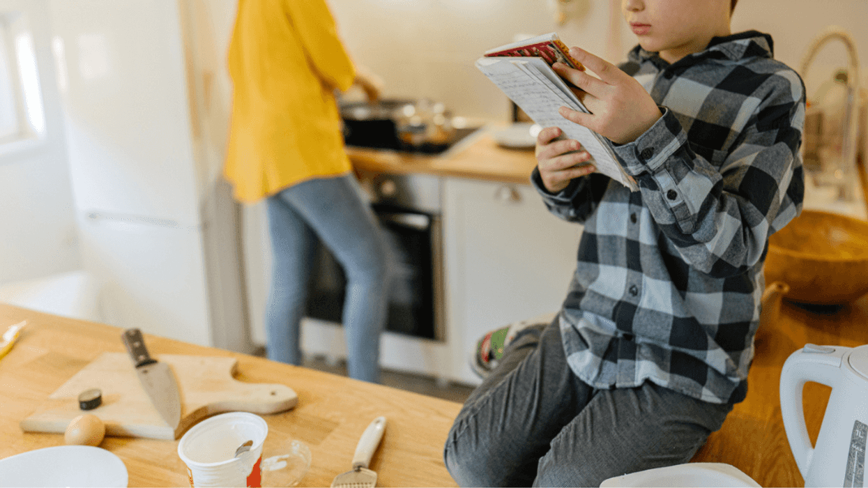 Mom and son looking at cookbook and cooking in the kitchen