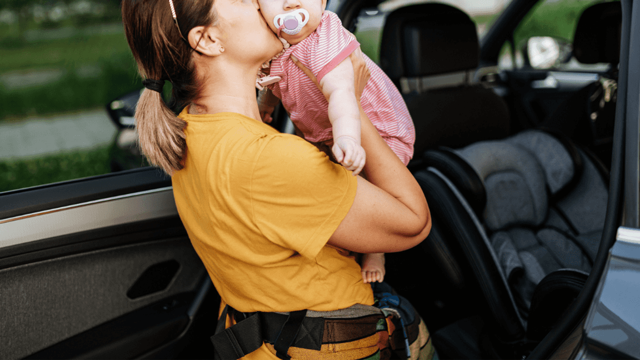 Mom putting her baby into a carseat