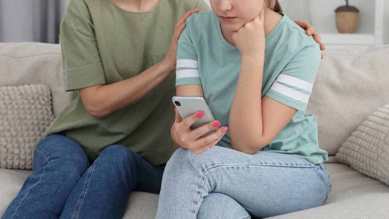 Mother comforting her upset teen daughter at home.