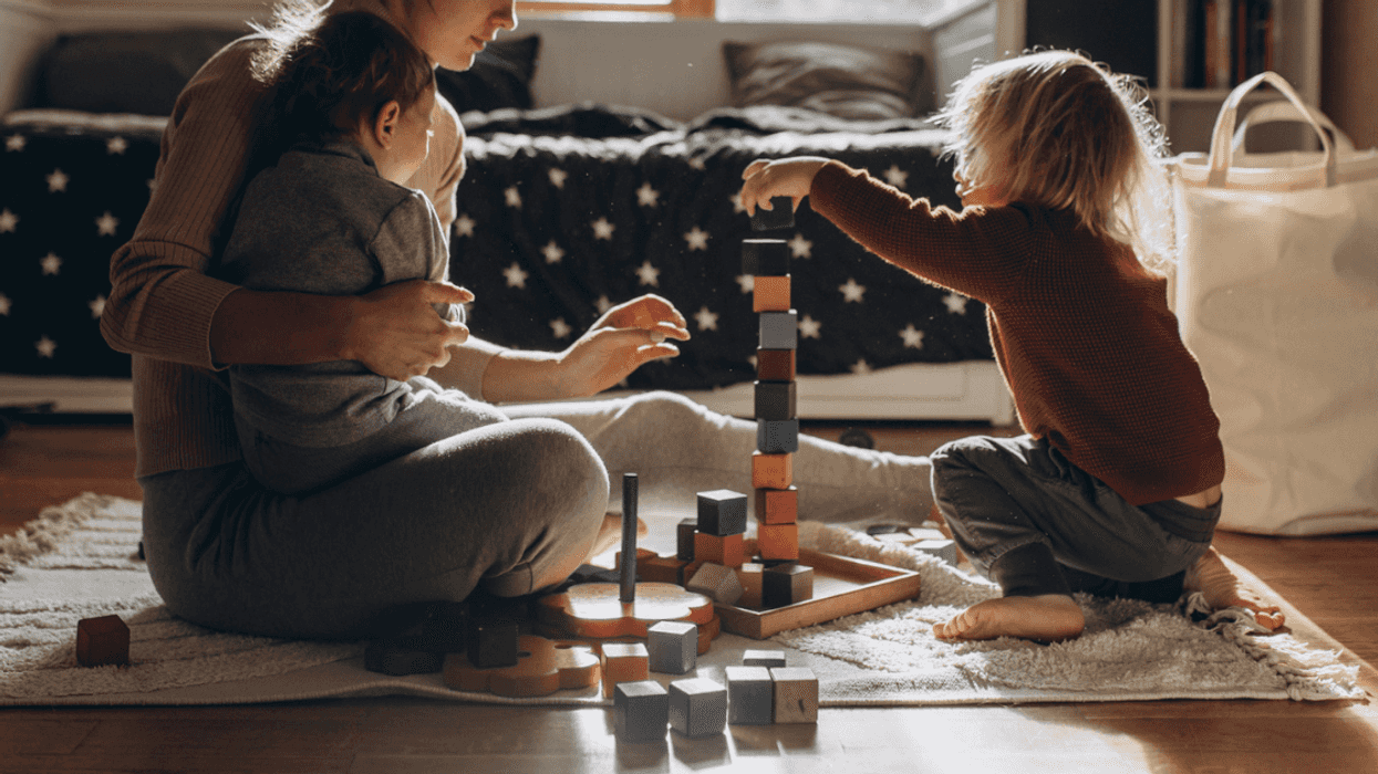Mother with her two young children at home during workday
