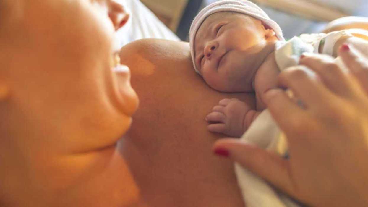 Mother with newborn baby son lying in hospital bed.