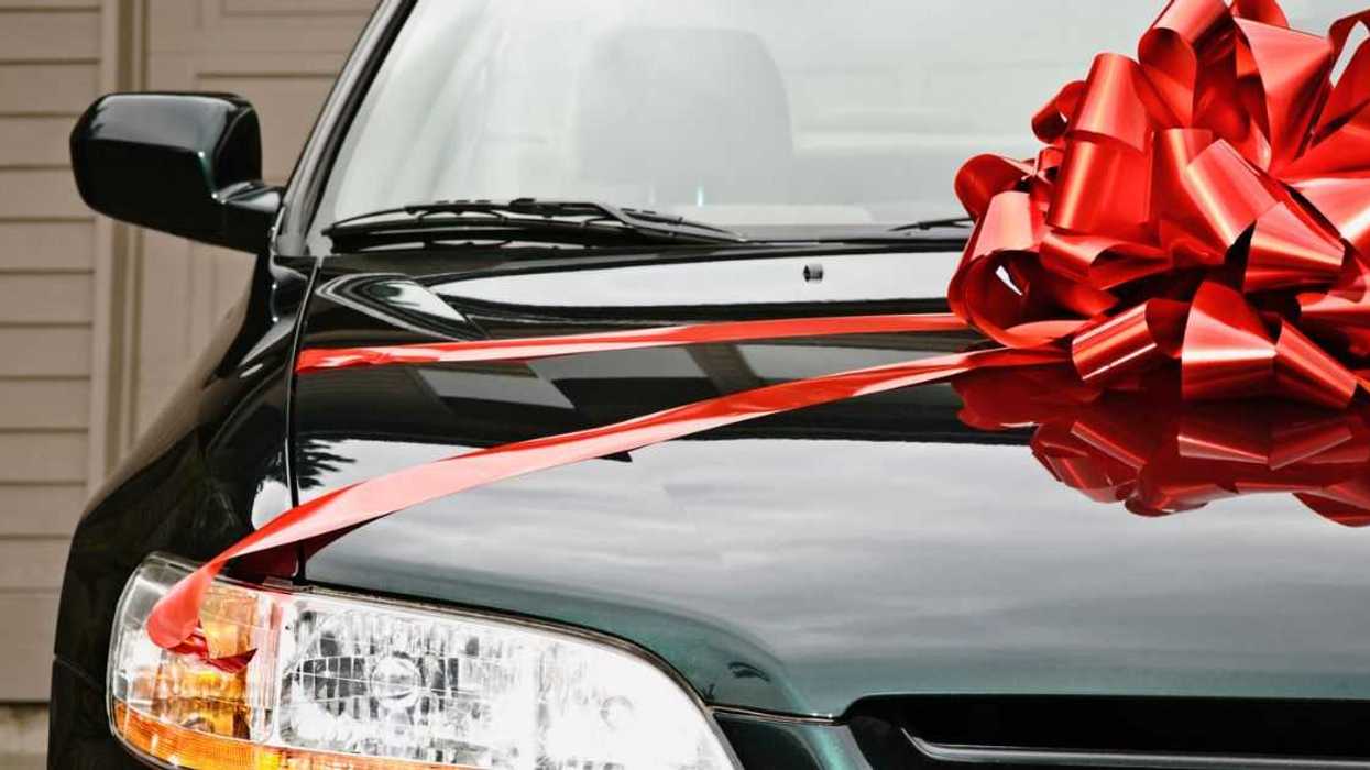 New black car with red ribbon on the hood.