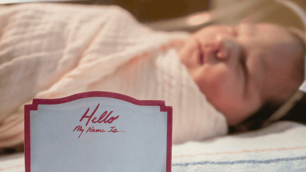 Newborn baby with name placard