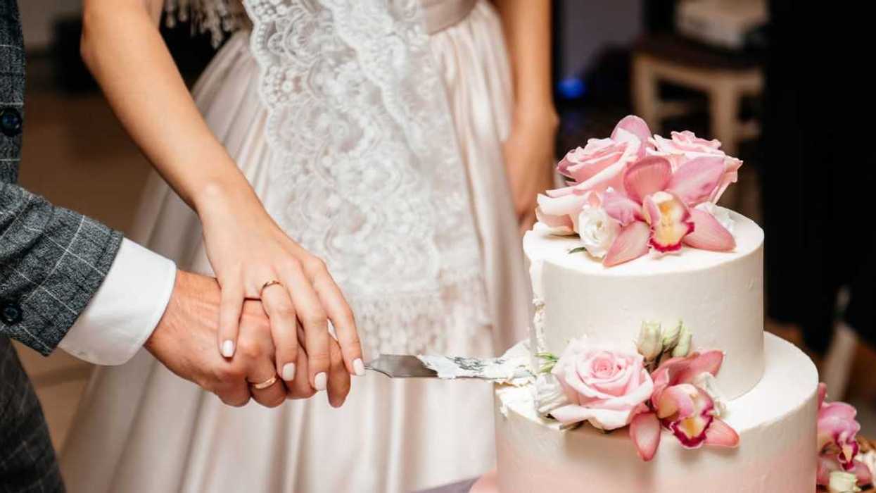 Newlyweds cutting wedding cake.