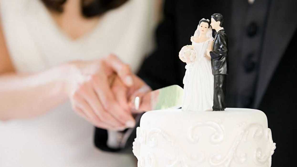 Newlyweds cutting wedding cake.