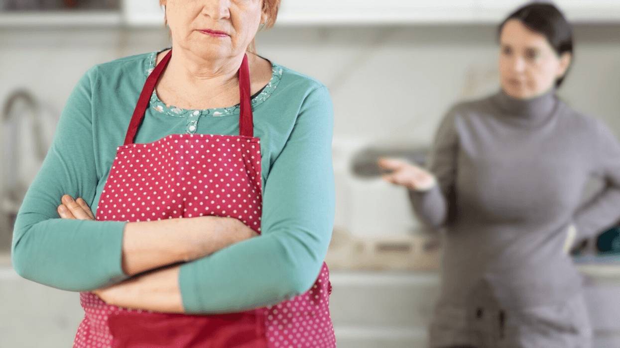 older and younger women argue in kitchen