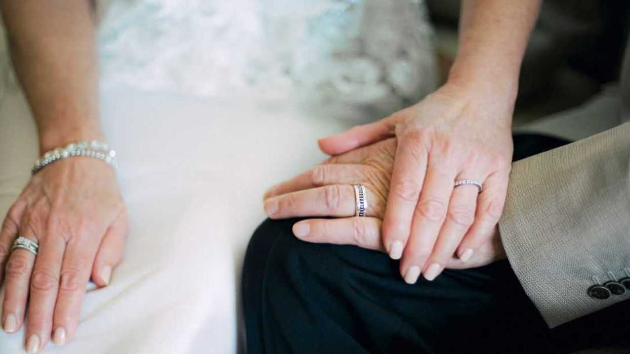 Older Bride and groom hands wearing wedding rings.