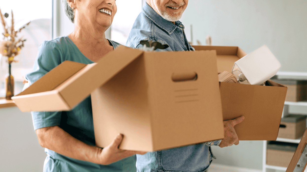 Older couple carrying moving boxes