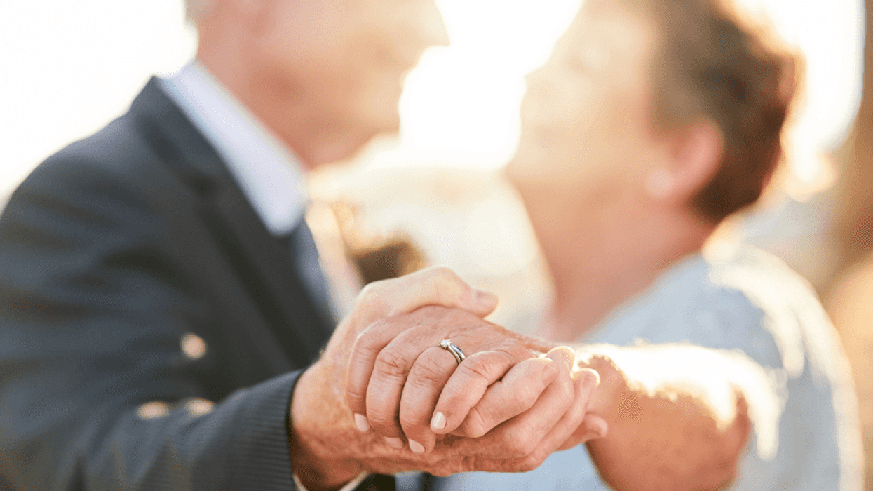 Older couple dancing showing a wedding ring.