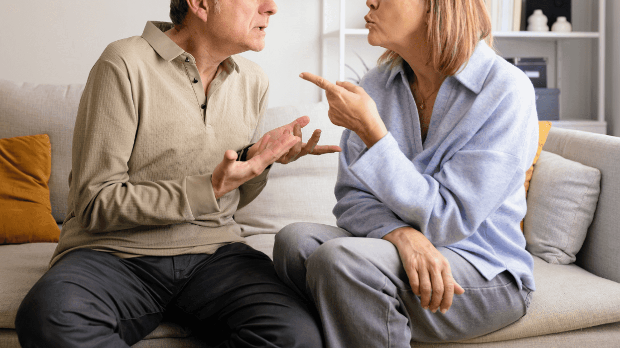 older couple seated on couch arguing