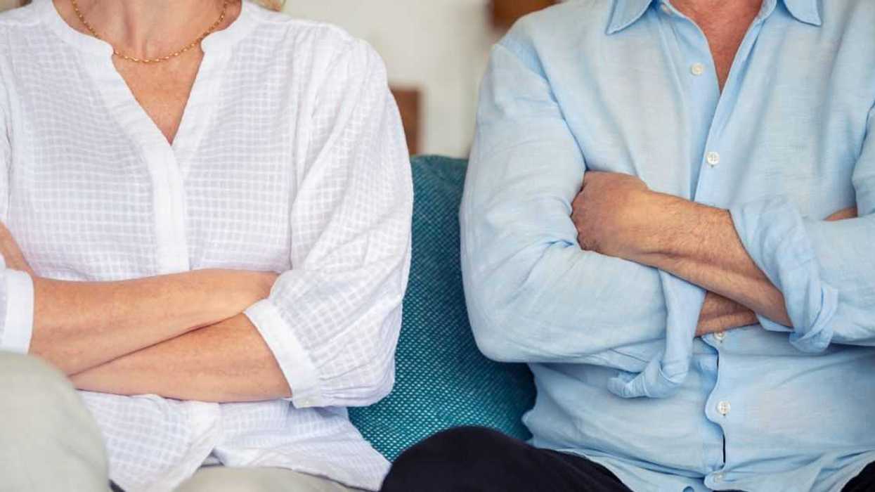 Older couple sitting together with arms crossed