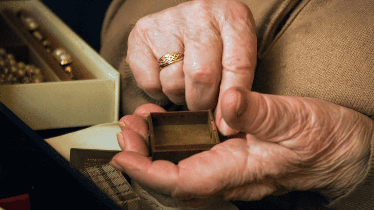 older person sorts through jewelry