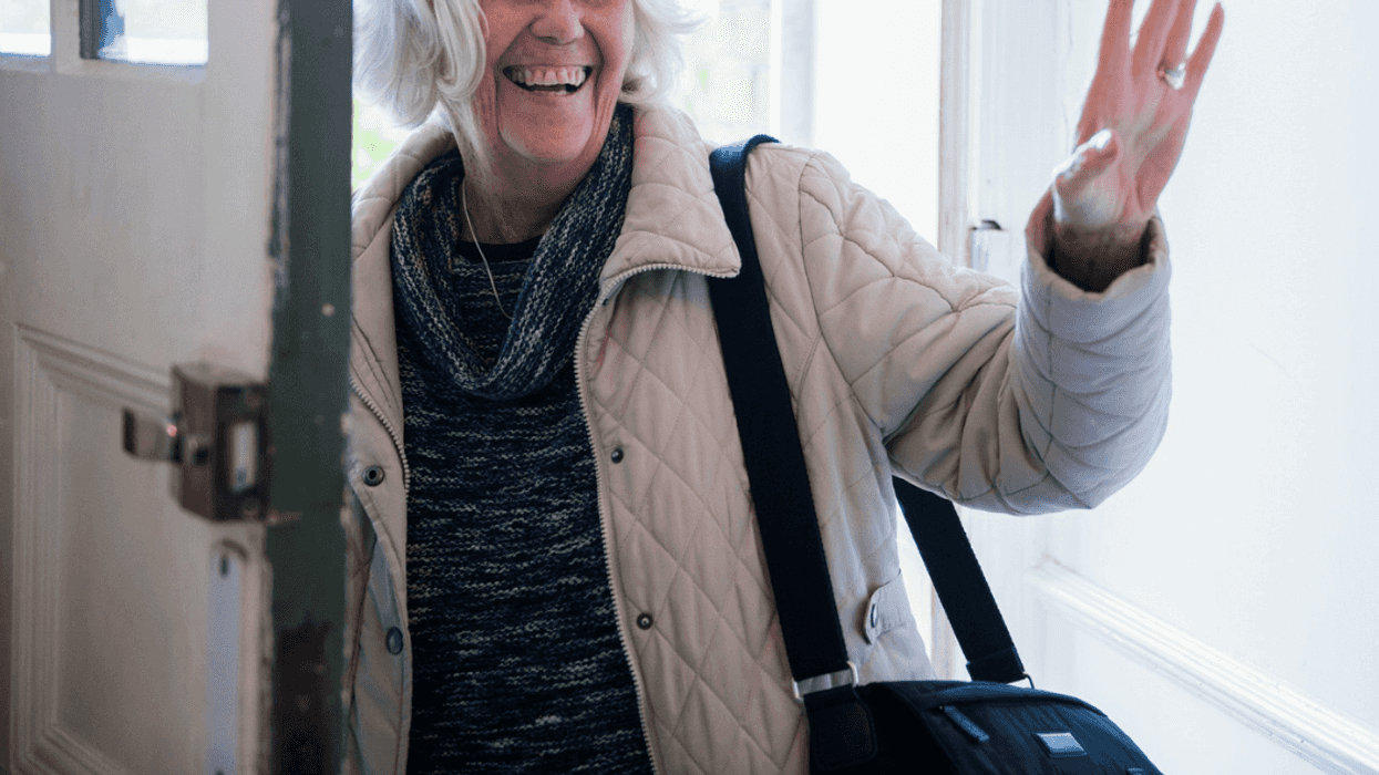 older woman coming through door of home
