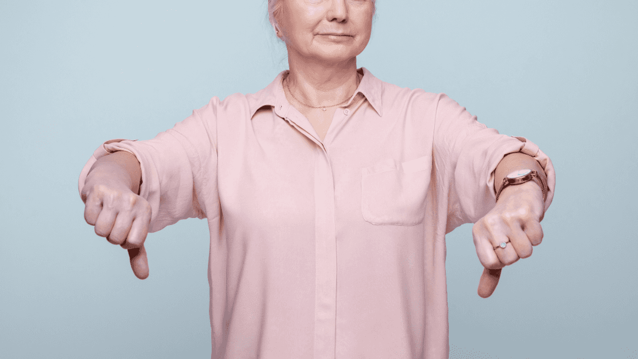 older woman giving two thumbs down