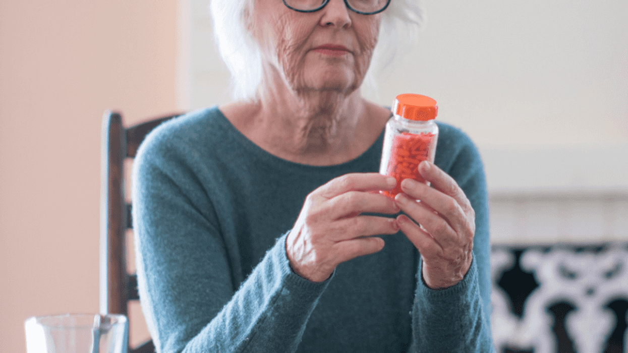 Older woman holding a prescription pill bottle