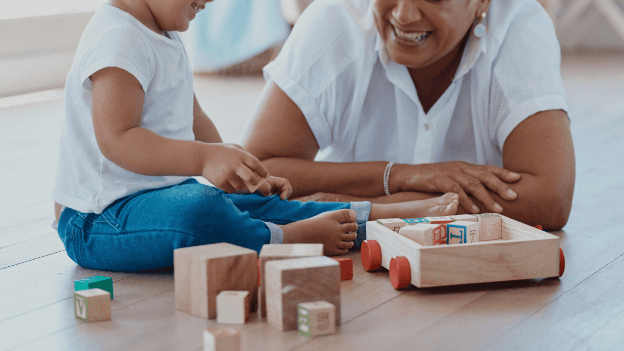 older woman on floor playing with toddler