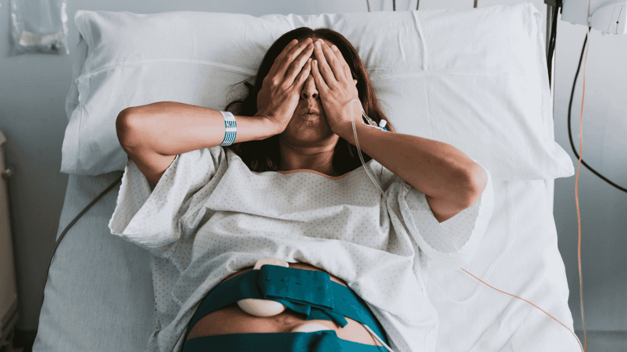 Overwhelmed pregnant woman in delivery room