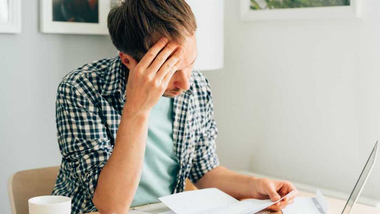 Pensive man thinking about high prices. Managing family finances. Rise of utilities, gas, electricity, rental charges, water bill due to inflation and global crisis. Facing downturn including energy. Planning family budget while sitting in kitchen.