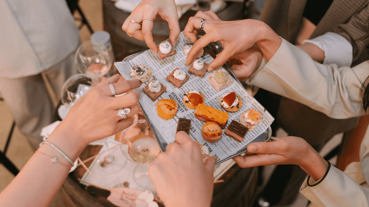 people taking finger food from tray at party