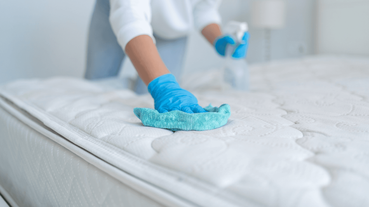 person cleaning mattress