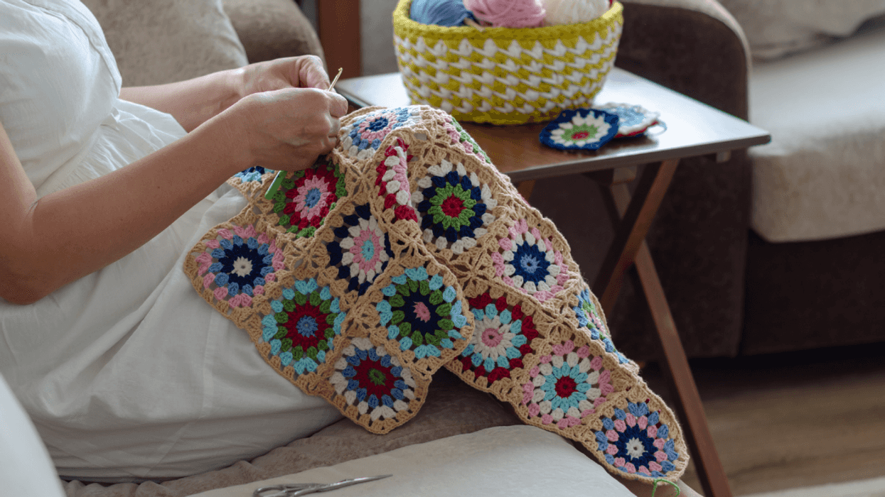person crocheting blanket