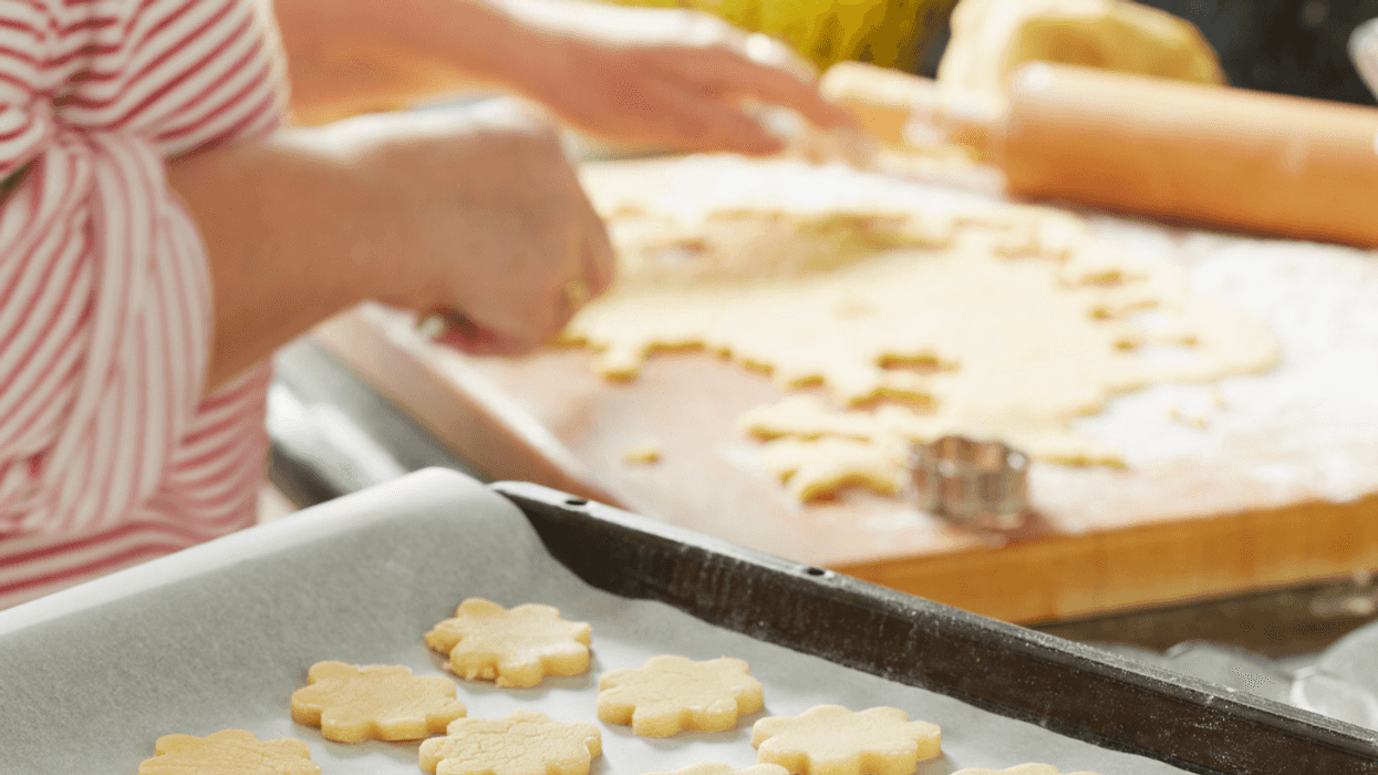 person cutting out cookies