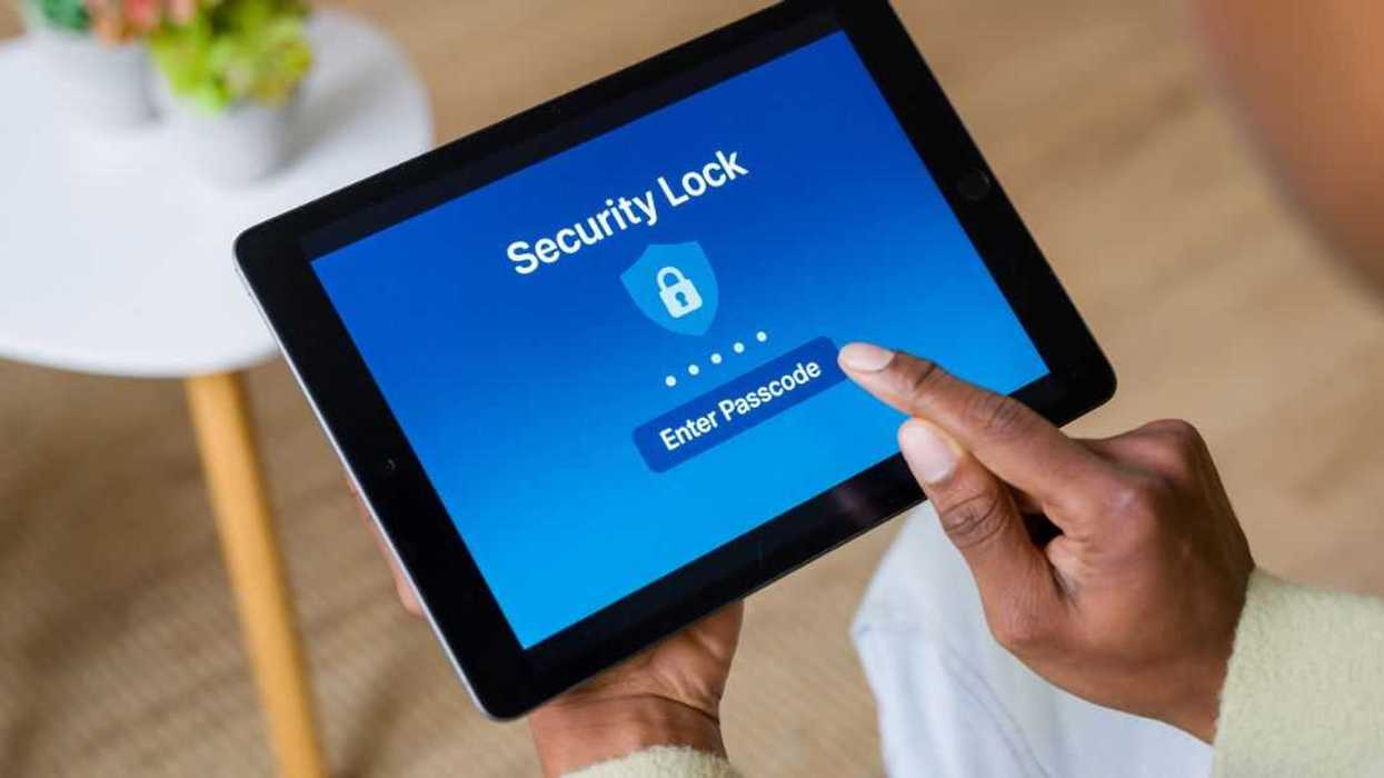 Person entering a passcode on a tablet to unlock the security system.