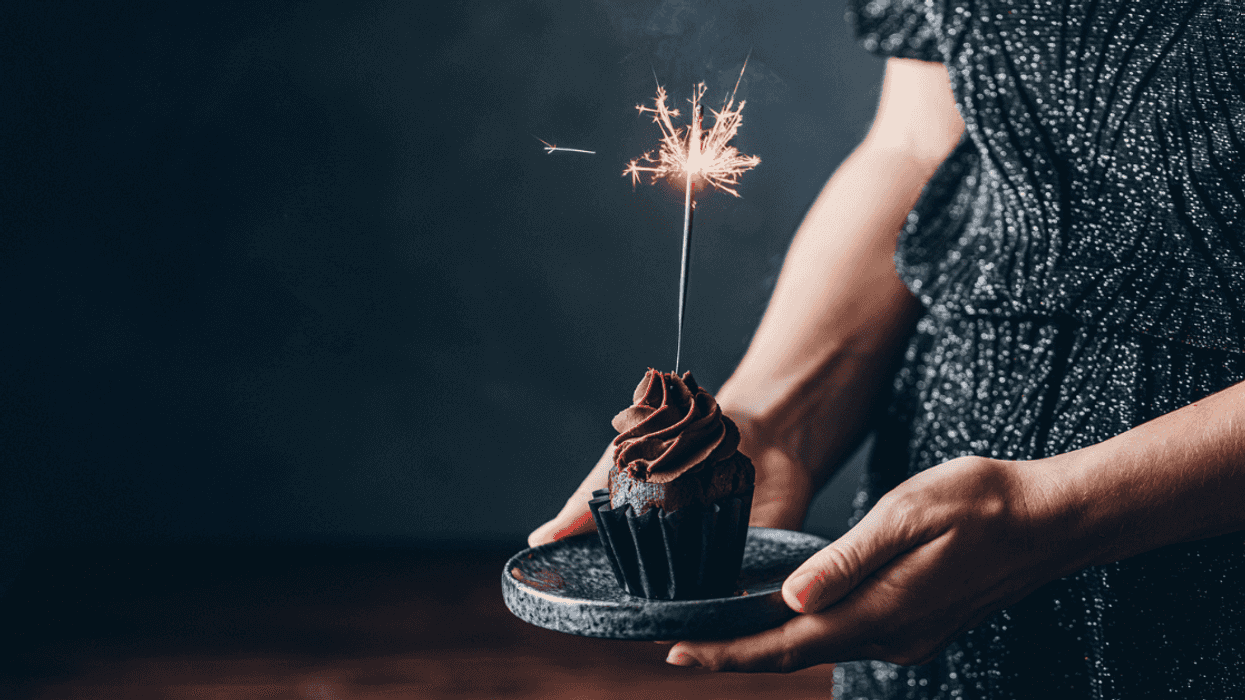 Person holding a birthday cupcake