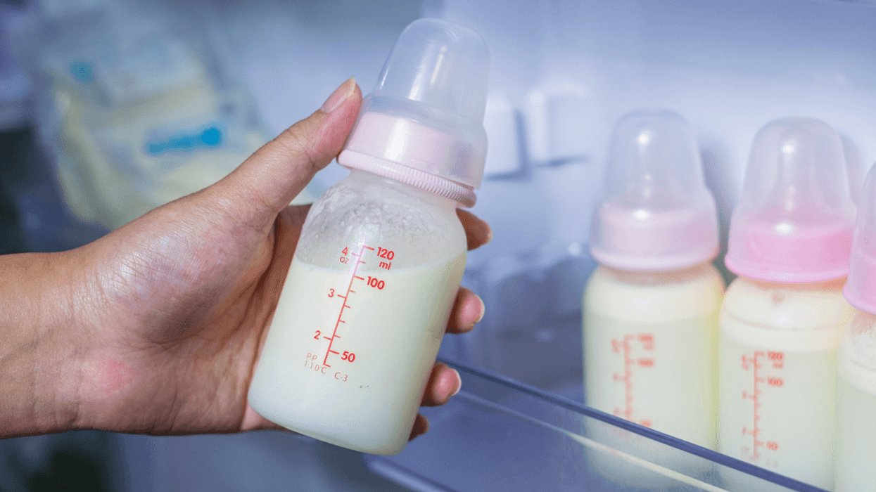 Person holding a bottle of breast milk