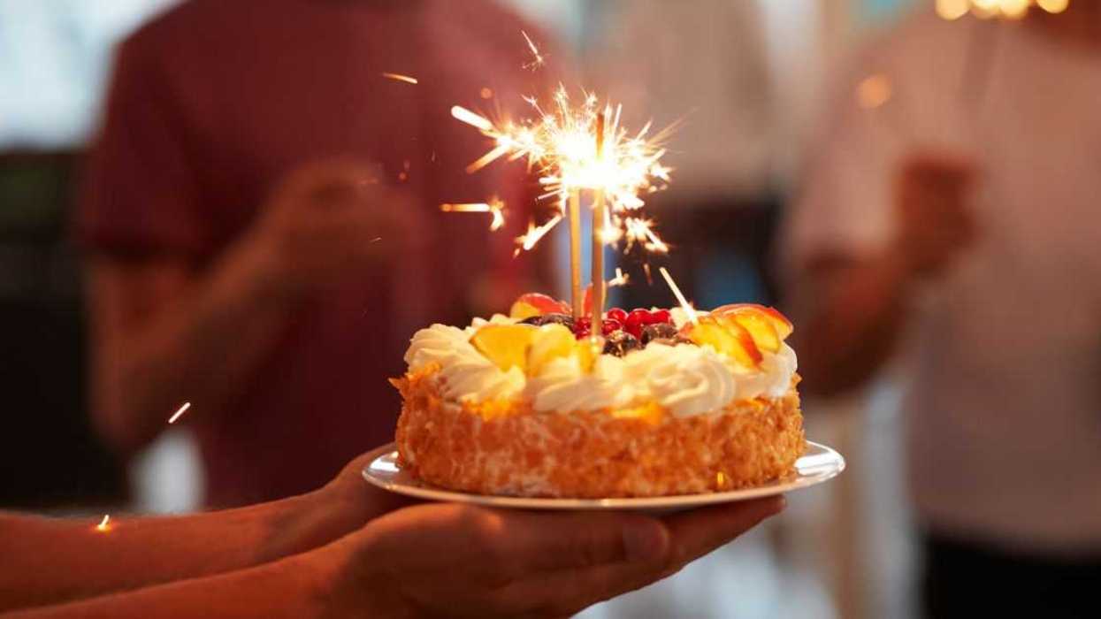 Person holding birthday cake.